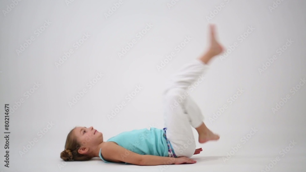 Little girl makes gymnastic exercise lying on your back Little girl makes gymnastic exercise lying on your back