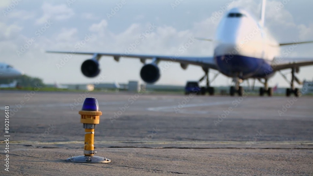 Aircraft stands on aerodrome with lantern of runway illumination Aircraft stands on aerodrome with lantern of runway illumination
