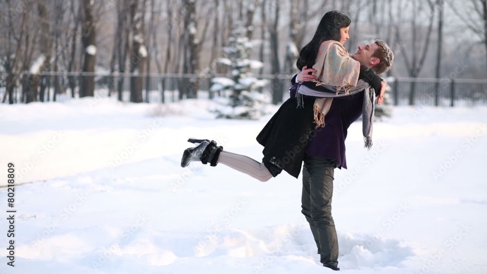 Young man and woman embrace and go in winter park and embrace Young man and woman embrace and go in winter park and embrace