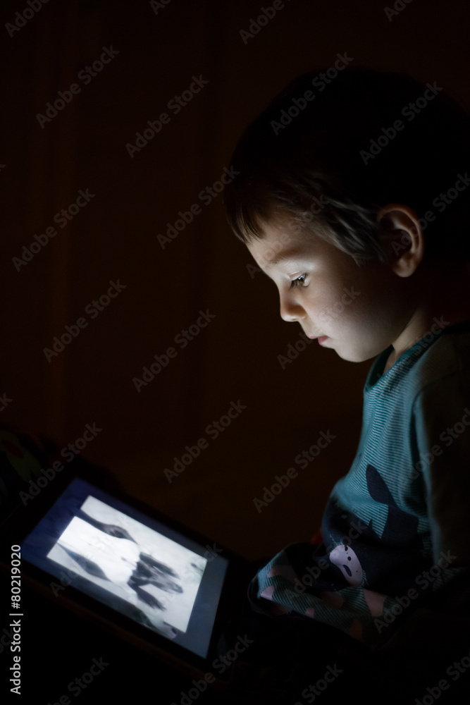 kid with tablet in the dark kid with tablet in the dark