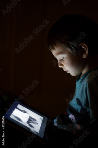 kid with tablet in the dark