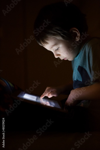 kid with tablet in the dark