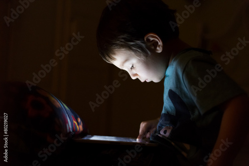 kid with tablet in the dark