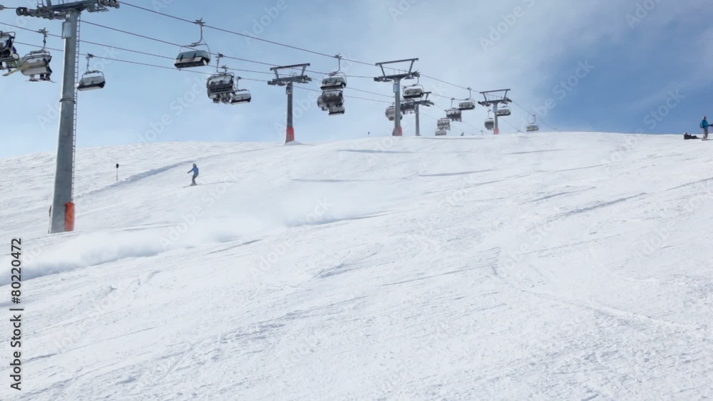 People ride ski near cableway on Austrian Alps at winter People ride ski near cableway on Austrian Alps at winter
