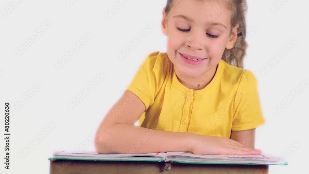 Little girl reads part of words from book aloud isolated Little girl reads part of words from book aloud isolated