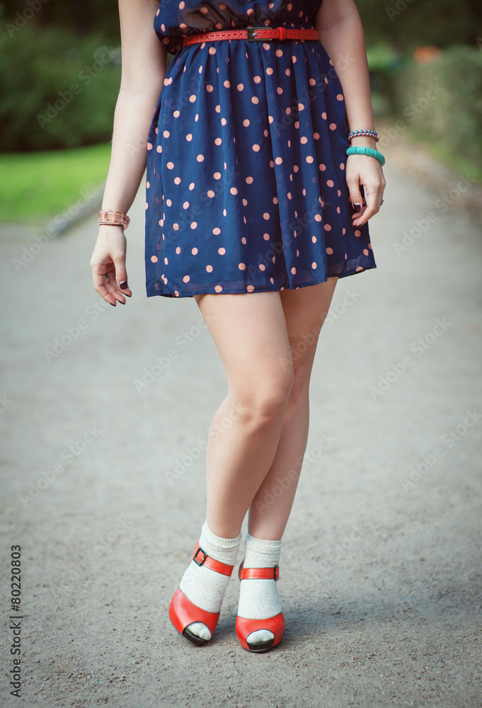 Red sandals with white socks on girl legs in fifties style