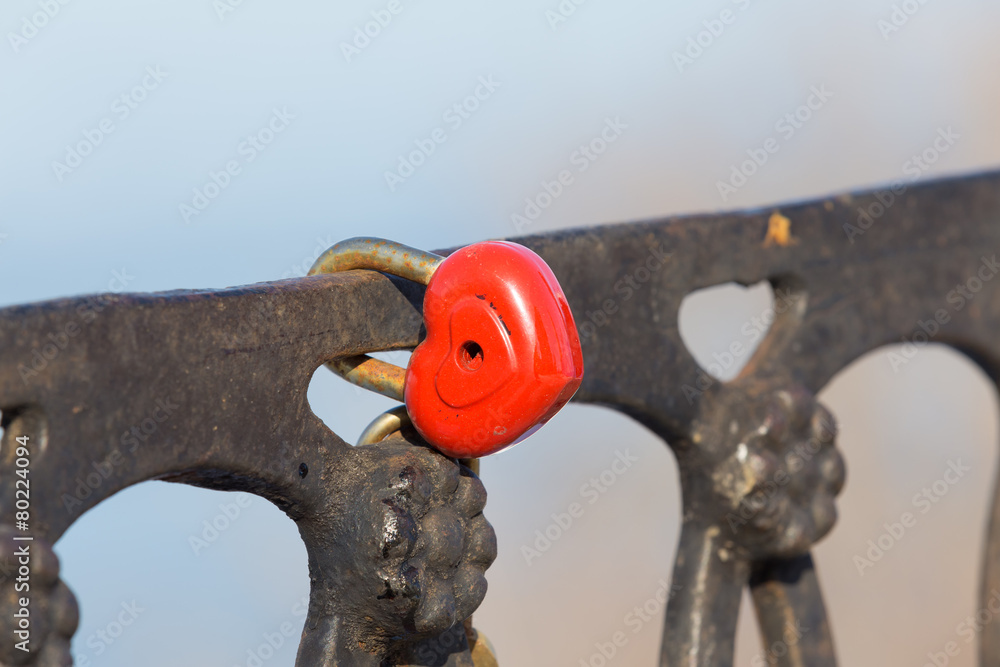 red heart-shaped lock on fence as sign of love red heart-shaped lock on fence as sign of love