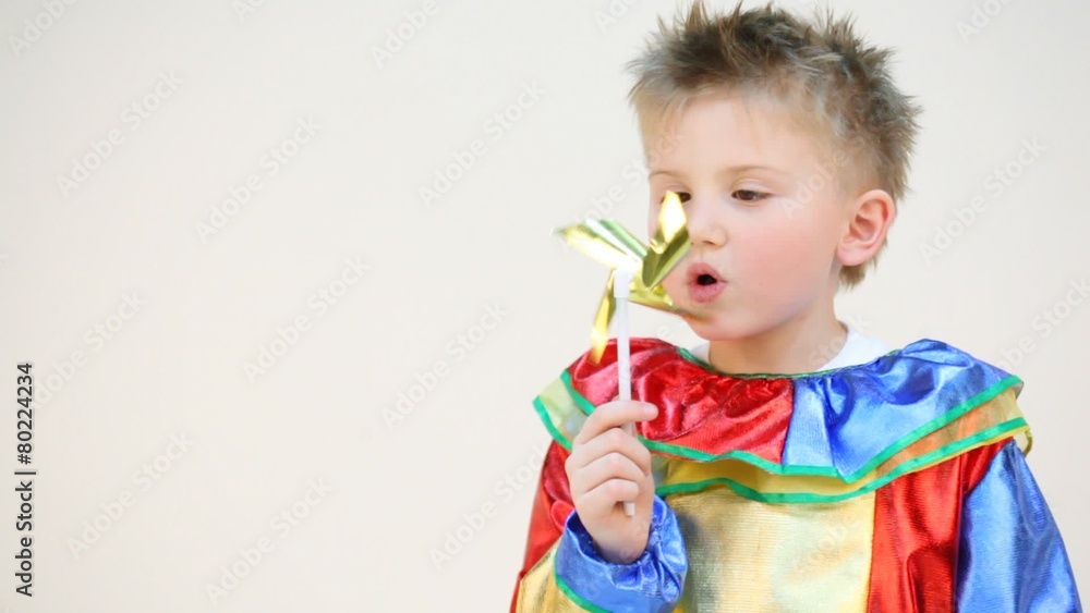 Little boy in costume with a windmill isolated on white Little boy in costume with a windmill isolated on white