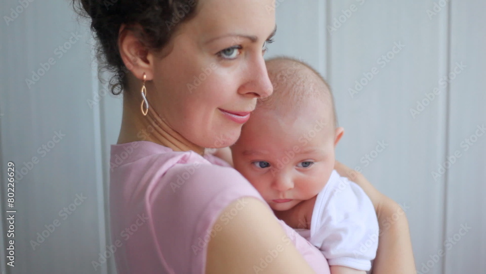 woman holds small baby at itself on hands and smiles woman holds small baby at itself on hands and smiles