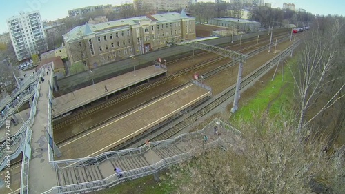 Passengers train rides away from railway station with passengers photo