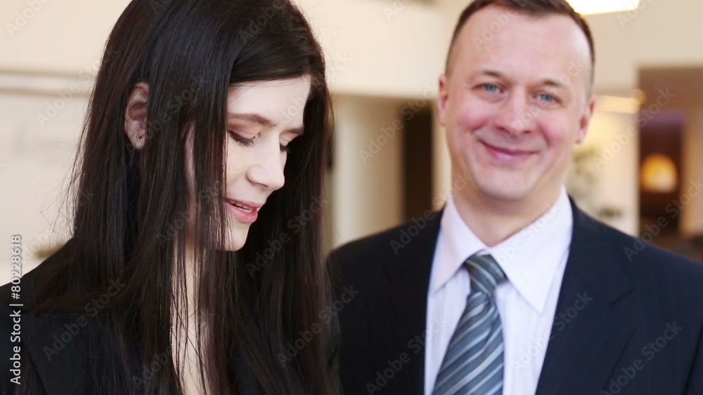 Man and woman in business suits talk. Focus on girl Man and woman in business suits talk. Focus on girl