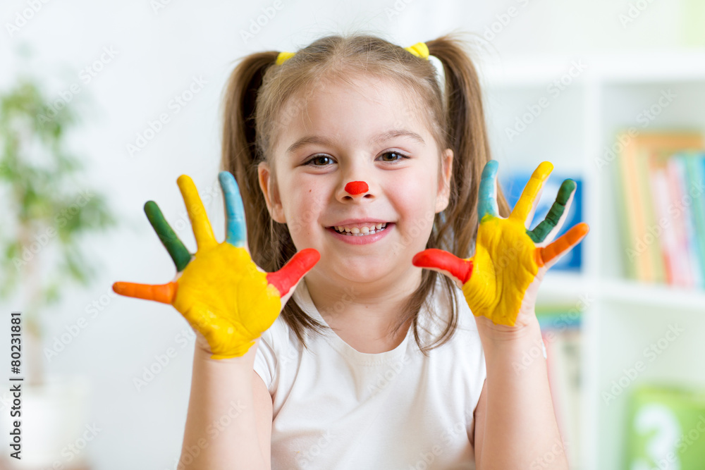 Fototapeta premium Five year old girl with hands painted in colorful paints