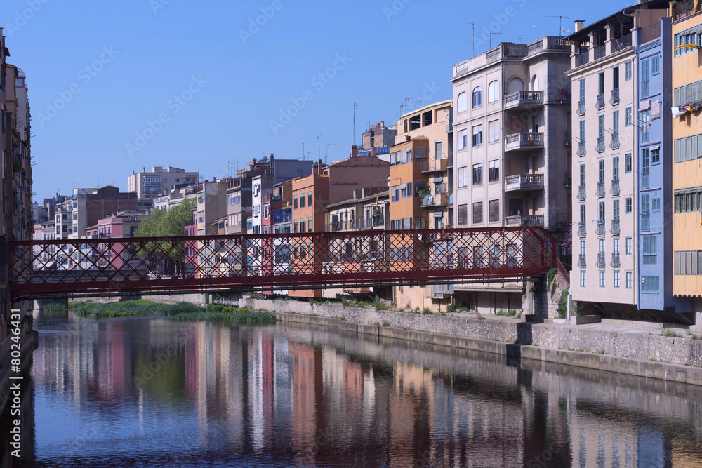 Eiffel bridge in Girona with facade with colorful houses