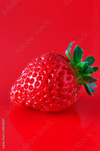Red strawberry on the red background
