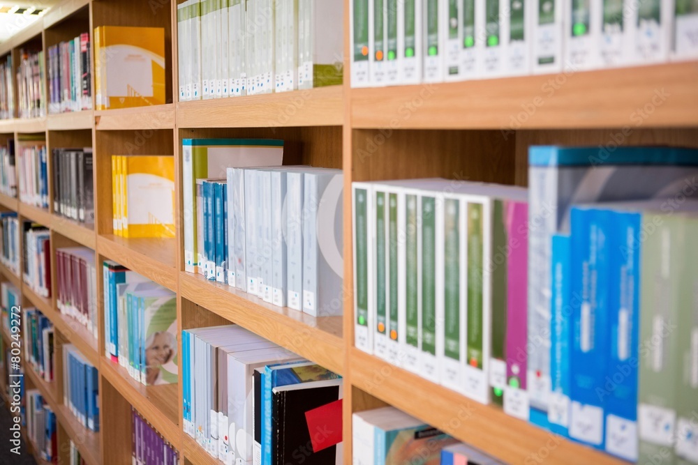 Volumes of books on bookshelf in library Volumes of books on bookshelf in library