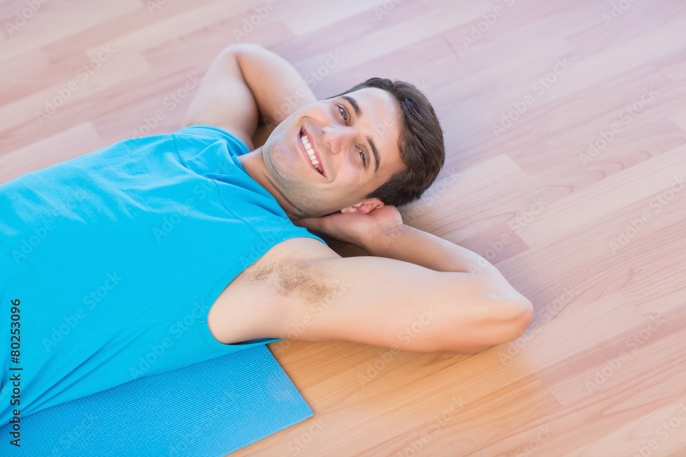 Smiling man lying on exercise mat