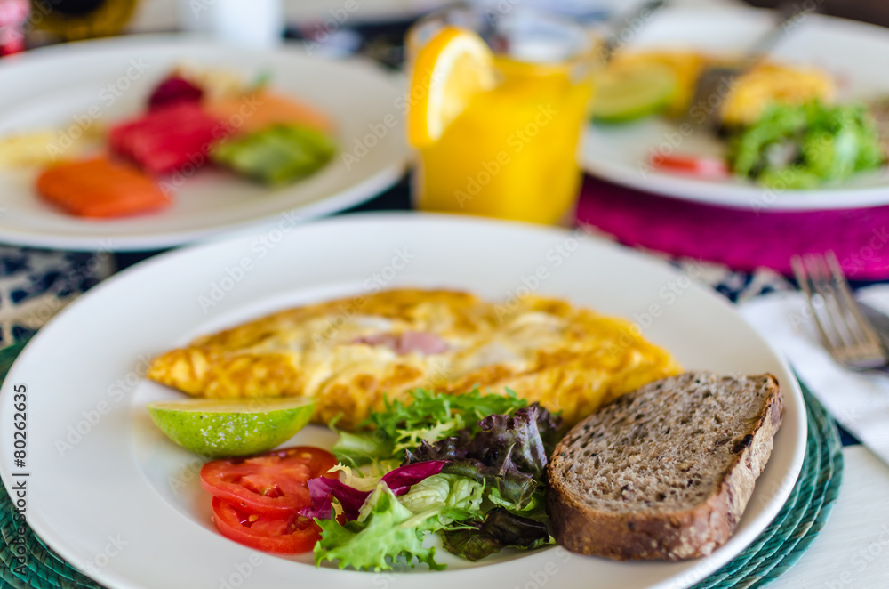 Delicious mexican style breakfast with omlette, ham and bread Delicious mexican style breakfast with omlette, ham and bread