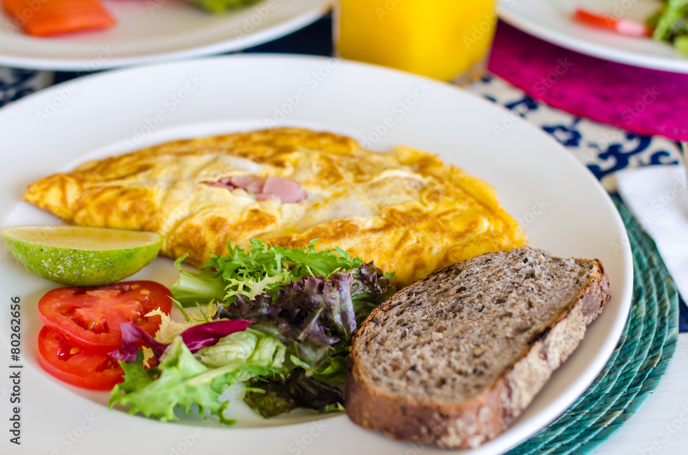 Delicious mexican style breakfast with omlette, ham and bread Delicious mexican style breakfast with omlette, ham and bread