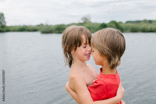 Fotografie Fraternal twins hugging at the beach