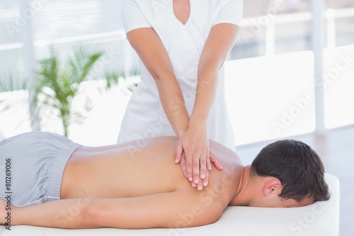 Physiotherapist doing shoulder massage to her patient