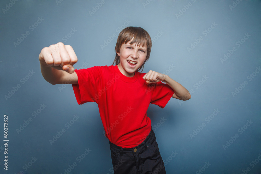 Boy, teenager, twelve his red in shirt, fists showing Boy, teenager, twelve his red in shirt, fists showing