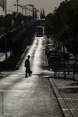 Teenager with hat crossing road sunrise silhoutte © boruchlen