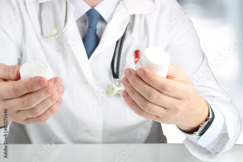 Doctor in a white labcoat choosing medicament between two drug