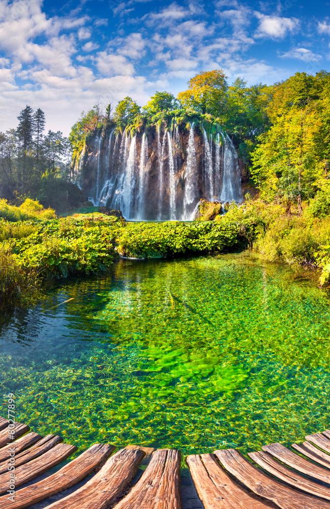 Obraz premium Landscape of a beautiful rock with a waterfall under the blue sk