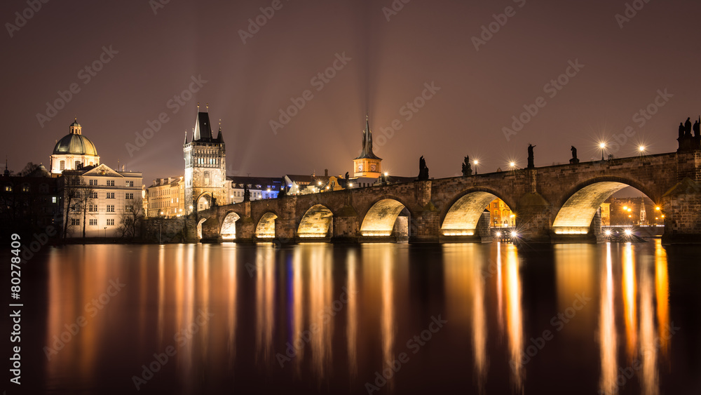 Night view of Prague and Charles Bridge over Vltava river .