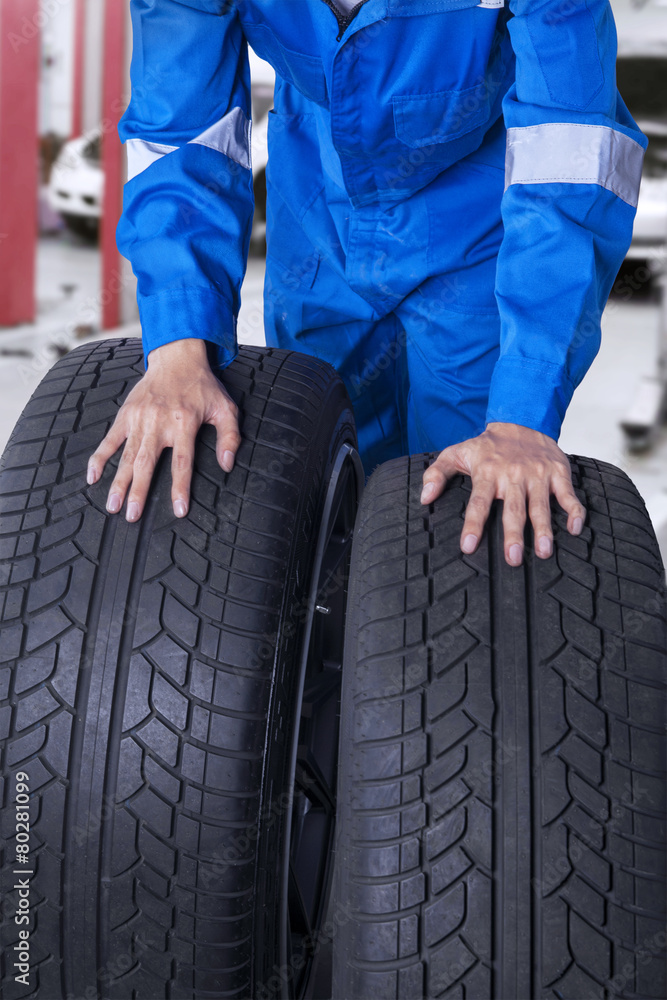 Two tires with mechanic in workshop Two tires with mechanic in workshop