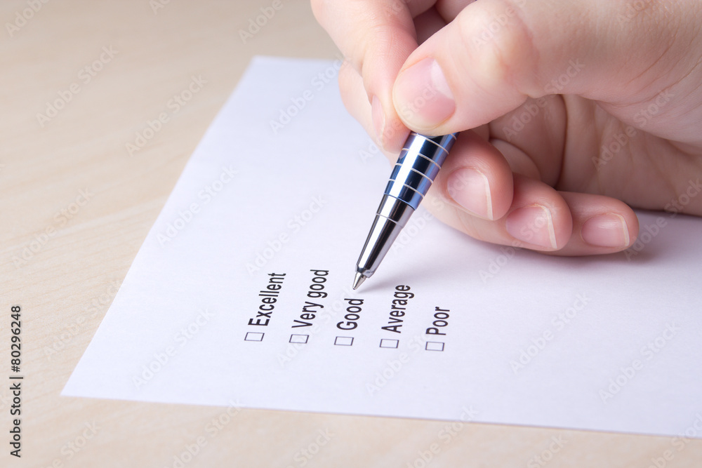 close up of female hand filling customer survey close up of female hand filling customer survey