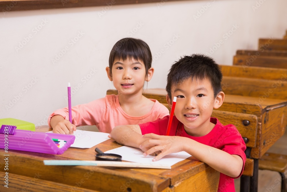 Cute pupils smiling at camera in classroom Cute pupils smiling at camera in classroom