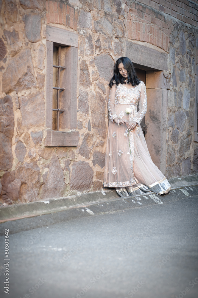 happy beautiful indian bride outdoors against stone building happy beautiful indian bride outdoors against stone building