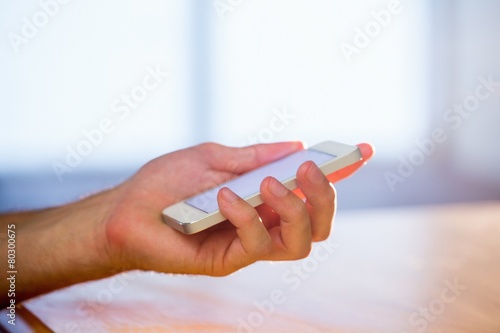 Hand holding a white smartphone