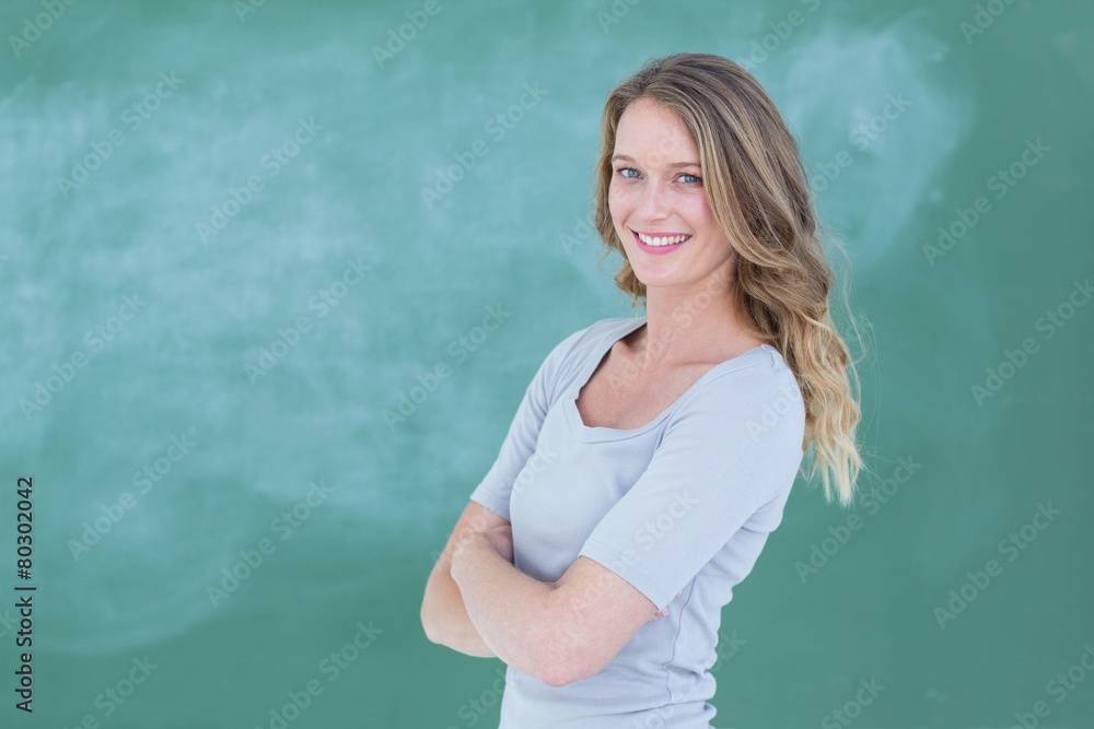 Smiling teacher standing in front of blackboard Smiling teacher standing in front of blackboard