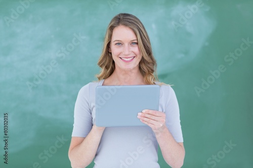 Smiling teacher holding tablet pc