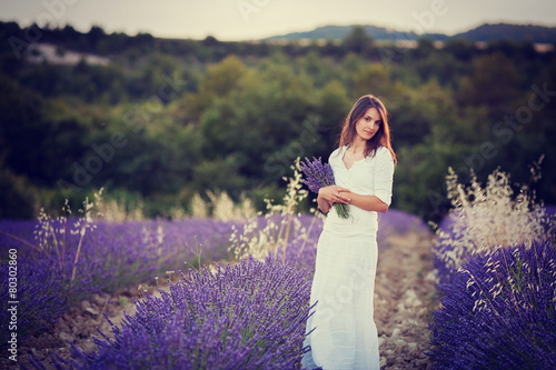 Beautiful young woman, holding lavender in a field