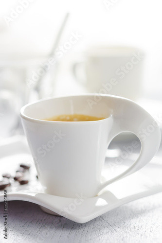 Cup of coffee on white wooden background