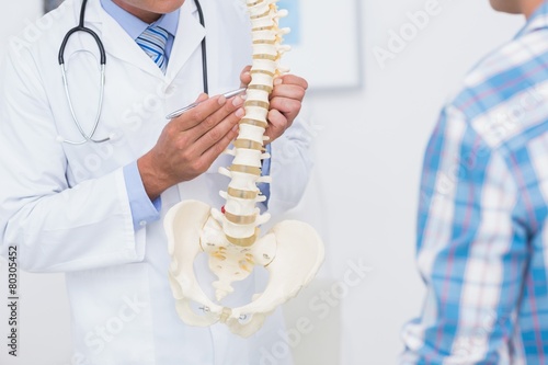 Doctor showing anatomical spine to his patient