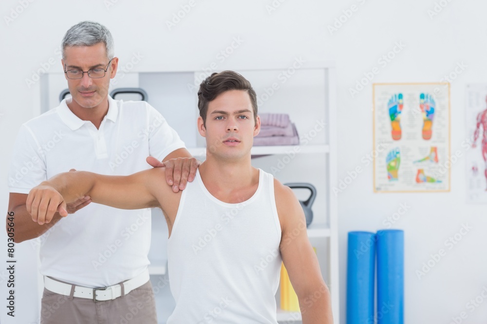 Fototapeta premium Doctor stretching a young man arm