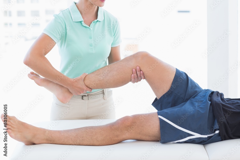 Obraz premium Doctor examining man leg