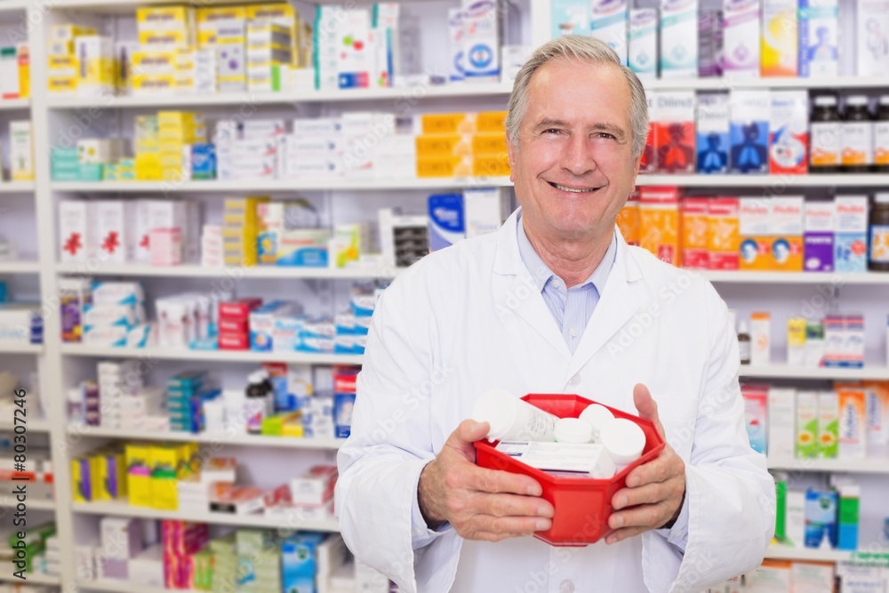 Senior pharmacist holding bowl of medicines