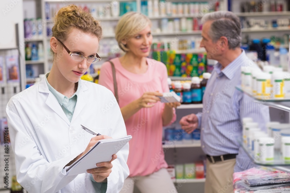 Pharmacist writing on clipboard Pharmacist writing on clipboard