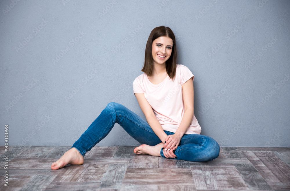 Happy young cute woman sitting on the floor