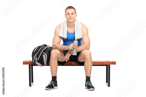 Athlete sitting on a bench holding a water bottle © Ljupco Smokovski