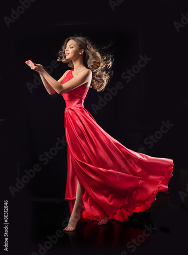 Young beauty woman in red waving flying dress. Dancer in silk d