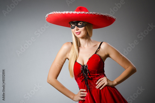 Woman wearing red sombrero and mask