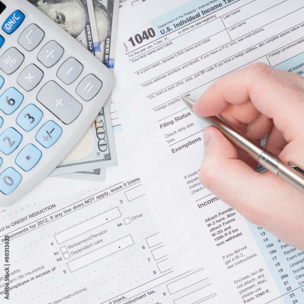 Taxpayer filling out USA 1040 Tax Form Taxpayer filling out USA 1040 Tax Form