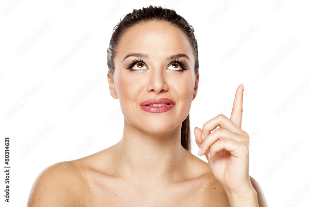 young woman looking up and pointing up young woman looking up and pointing up