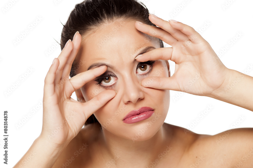 funny young woman holding her eyes open with her fingers funny young woman holding her eyes open with her fingers